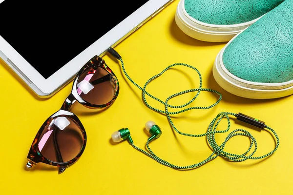 Solglasögon, hörlurar, blå skor och en smartphone — Stockfoto