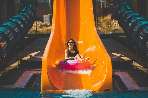 Signora scendendo dallo scivolo nel parco acquatico — Foto Stock