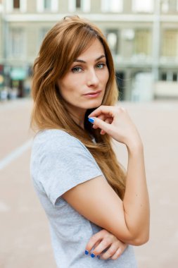 Genç thoughtfull Kızıl saçlı modeli şehirde yürüyüş