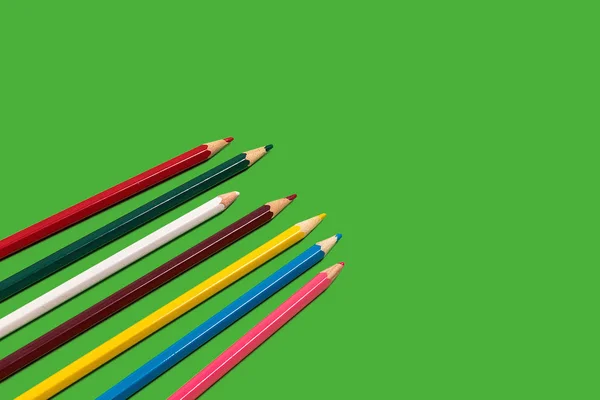 Кольорові олівці на зеленому фоні — стокове фото