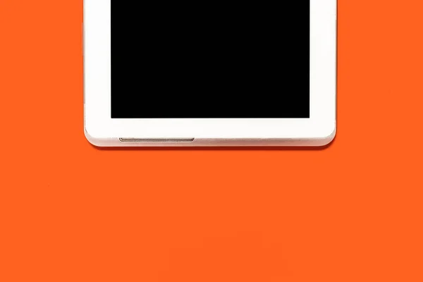 Планшетный компьютер на оранжевом фоне — стоковое фото
