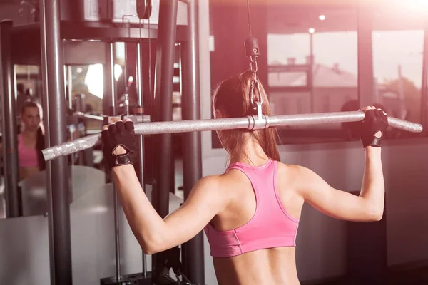 Frau trainiert mit Langhantel im Fitnessstudio — Stockfoto