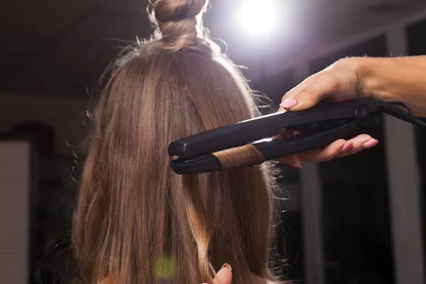 Cabeleireiro curling um fio de cabelo de uma menina — Fotografia de Stock