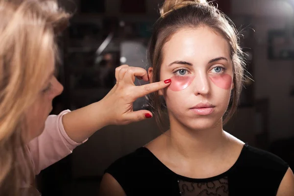 Bir kız hidrojel göz düzeltme eklerini uygulamayı makyaj sanatçısı — Stok fotoğraf