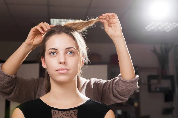 Cabeleireiro fazendo um penteado para um modelo — Fotografia de Stock