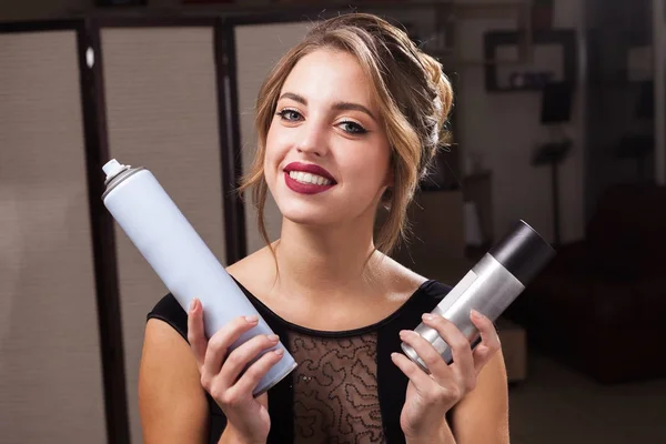 Smiling model holding two hair sprays — Stock Photo, Image