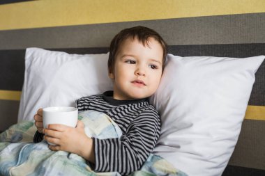 Hasta yatakta yatarken ilaç fincan ile kür çocuk üzgün