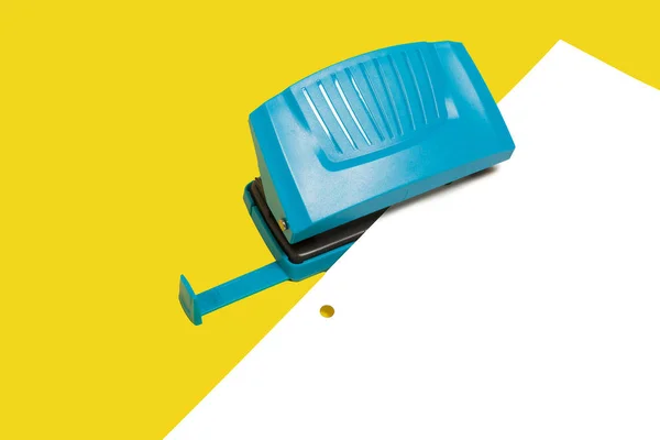 Perforador de agujero de oficina azul con una hoja de papel —  Fotos de Stock