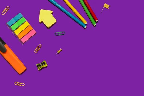 Uppsättning av olika skolmaterial på en lila yta — Stockfoto