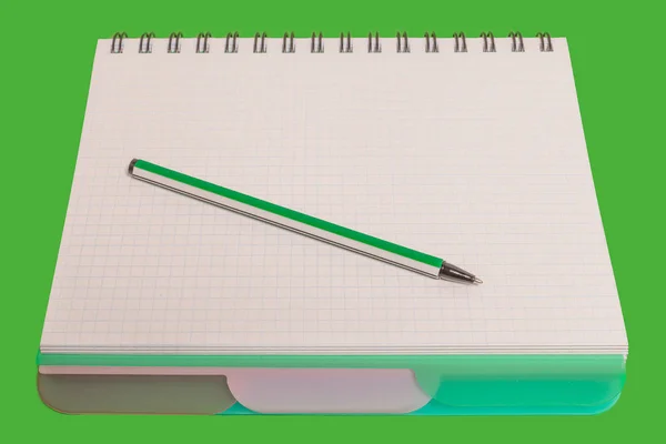 Green pen lying on a notebook — Stock Photo, Image