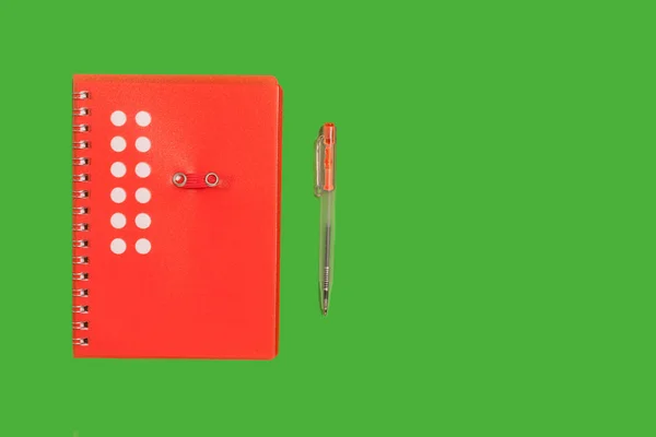 Cuaderno en espiral roja sobre una superficie verde —  Fotos de Stock