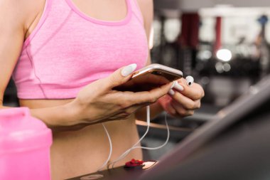 spor salonunda bir akıllı telefon tutan kadın yakın çekim