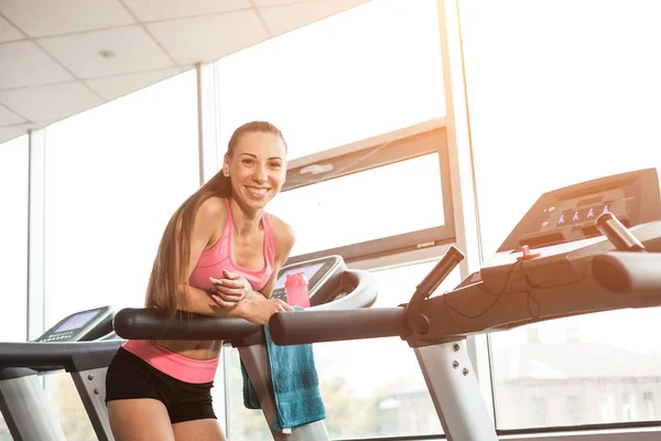 Chica apoyada en la cinta de correr —  Fotos de Stock