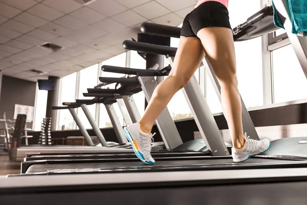 Girls legs running at the treadmill in the gym — Stock Photo, Image