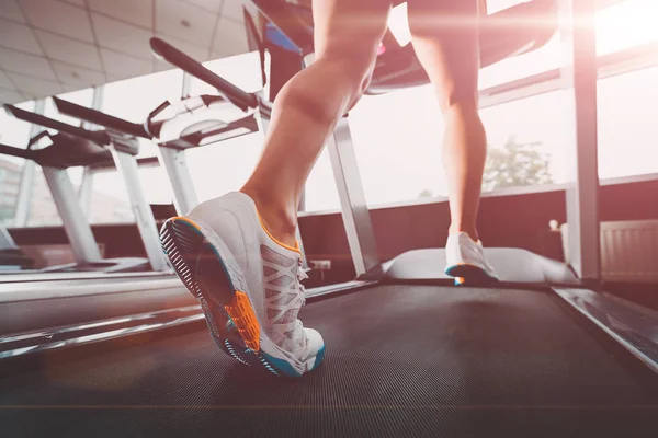 Жіночі ноги на біговій доріжці в спортзалі — стокове фото