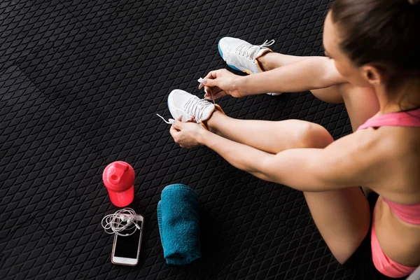 Chica atar entrenadores en el gimnasio — Foto de Stock