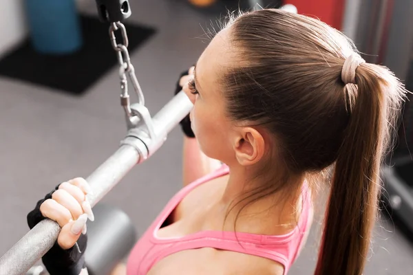 Mujer haciendo ejercicios con una barra en el gimnasio de cerca — Foto de Stock