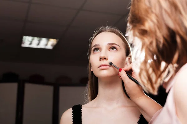 Maquiagem artista dabbing fundação em um cliente — Fotografia de Stock