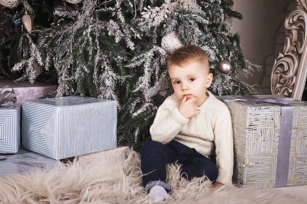 실내 크리스마스 트리 아래에 앉아 작은 소년 — 스톡 사진