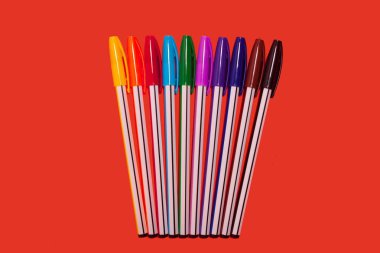 renkli kalemler kırmızı bir arka plan üzerinde yalan