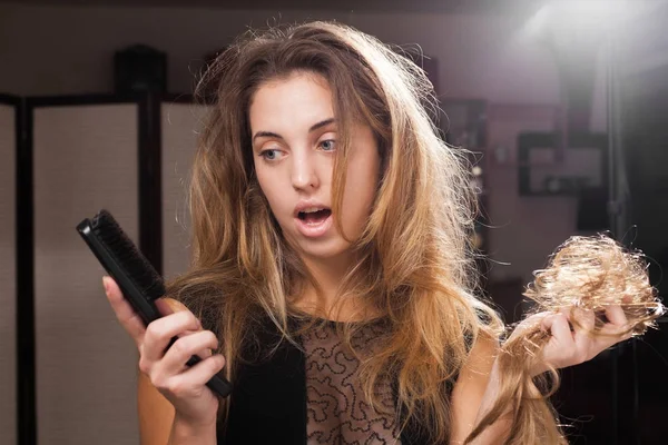Спантеличена красива дівчина виявляє випадання волосся на щітці для волосся — стокове фото