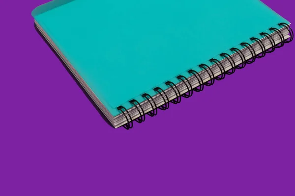 Notebook a spirale blu su sfondo viola — Foto Stock