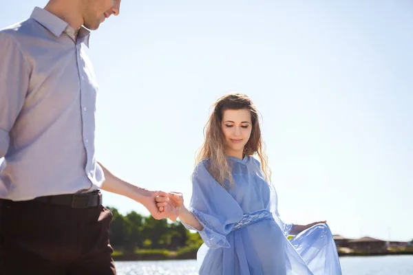 Przyszła matka i ojciec chodzenie w pobliżu jeziora trzymając ręce razem — Zdjęcie stockowe