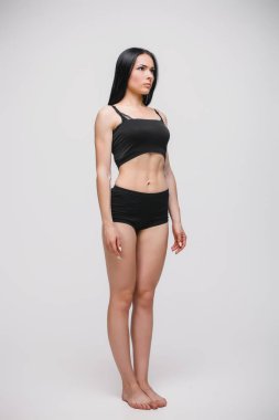 gri arka planda duran siyah iç çamaşırı modeli