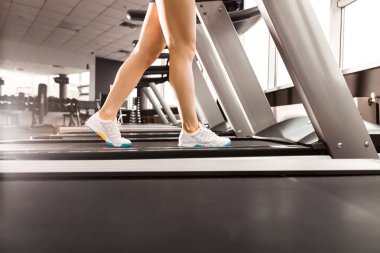 spor salonunda koşu bandında yürüyen kadın bacakları