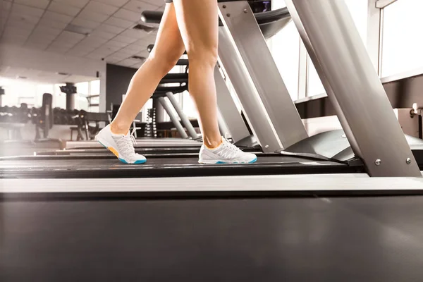 Жіночі ноги, що йдуть на біговій доріжці в спортзалі — стокове фото