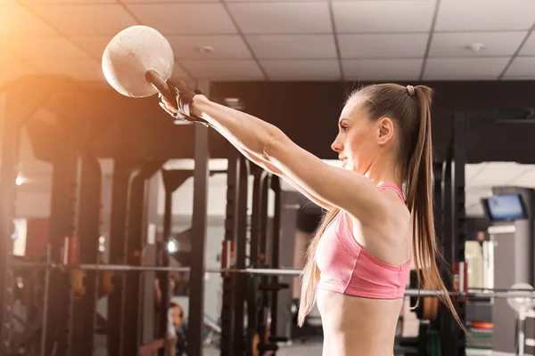 Mujer atlética haciendo ejercicios con una kettlebell — Foto de Stock