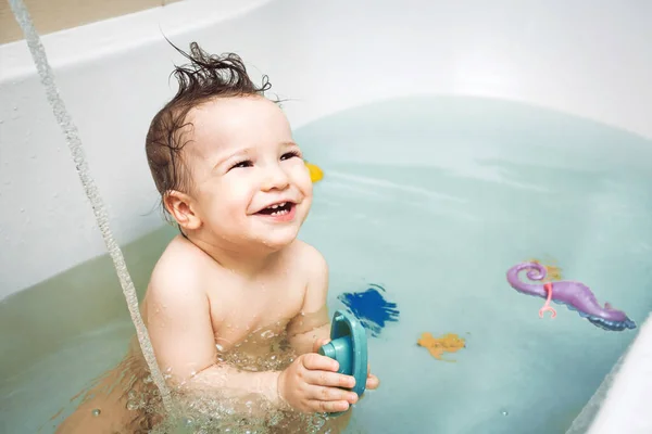 Schattig klein baby wassen in bad Stockfoto