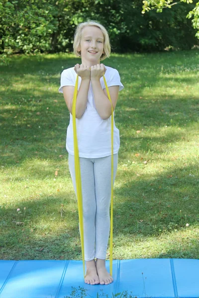 美丽的学校岁的女孩玩运动与橡胶带和垫子在户外公园 健康的生活方式 户外锻炼 — 图库照片