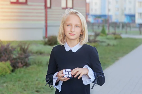 Schöne Und Kluge Blonde Mädchen Löst Ein Würfel Puzzle Außerhalb — Stockfoto