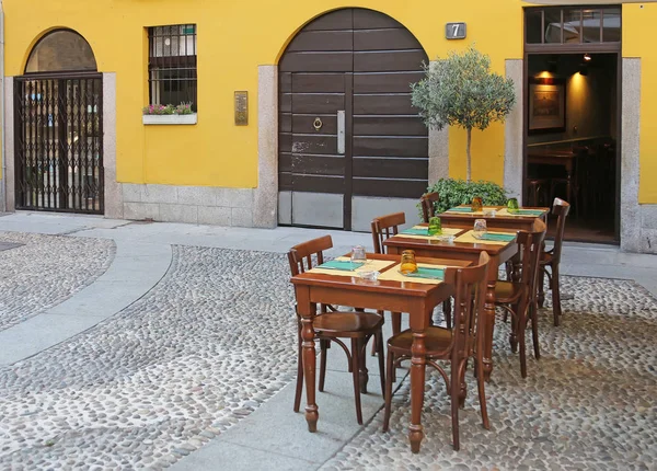 Outdoor italian restaurant with chairs and tables.