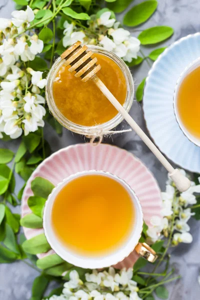 Vintage Tassen Mit Tee Neben Einem Glas Honig Und Akazien — Stockfoto