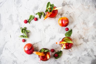 Yaz serinletici içecek meyve ile hafif ve meyveler - sangria ile nane yaprakları ve ahududu meyveleri bir daire içinde eğe. Üstten görünüm, düz yatıyordu. Boşaltmak