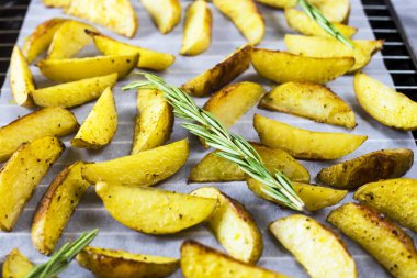 Bir fırın tepsisine adet baharat ve biberiye fırında patates. Mutfakta yemek ev yapımı