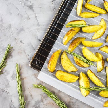 Bir fırın tepsisine adet baharat ve biberiye fırında patates. Arka plan. Üstten görünüm, düz yatıyordu