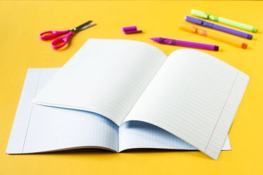 Dizüstü bilgisayarlar bir kutu ve bir satır tutamaçları sarı bir arka plan üzerinde yakın. Çalışma için aksesuarlar. Geri okul kavramı