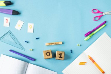 1 Eylül mavi bir arka plan üzerinde çalışma için malzemeler arasında ahşap bir takvim. Geri okul kavramı