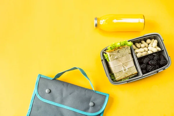 午餐盒里有食物 三明治 坚果和浆果 旁边放一瓶橙汁和一个午餐包 可以带给你的食物 顶部视图 — 图库照片