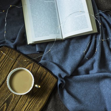 Bir fincan kahve süt ve rahat iç plohad bir kitap. Sonbahar ya da kış dinlenme zamanı. üstten görünüm, düz yatıyordu