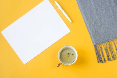 Yukarı alay - beyaz kağıt bir fincan kahve ve bir sonbahar eşarp yanında. Üstten görünüm, düz yatıyordu