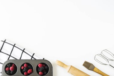 Ahududu ve böğürtlen için Wight'deki / arka plan için yemek - mutfak aksesuarları arasında üzerinde pişirme kek formunda haddeleme pin ve çırpma teli bir mikser çilek. Üstten görünüm, düz yatıyordu, kopya alanı