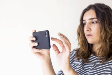 Kız bir smartphone basılı tutup ekran tuşuna basarak. Teknoloji ve online hayat