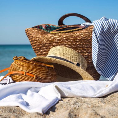 Bayanlar modern yuvarlak dokuma çanta şapka ve diğer aksesuarlar yanındaki sahilde beyaz zemin üzerinde. Deniz kavramı ile dinlenmek için şeyler