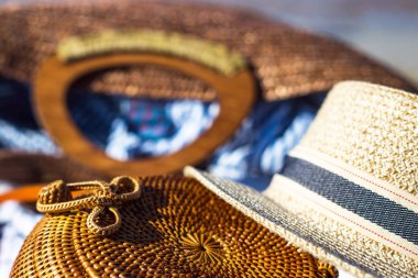 Bayanlar modern yuvarlak dokuma çanta şapka ve diğer aksesuarlar yanındaki sahilde beyaz zemin üzerinde. Deniz kavramı ile dinlenmek için şeyler