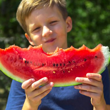 Holding ve büyük bir dolu dilim kırmızı olgun karpuz yeme beyaz çocuk. Yaz ve sonbahar sezonu. Sağlıklı çiğ gıda ve vitamin kavramı
