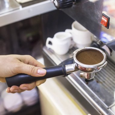 Espresso bir barista elinde çekilmiş kahve ile bir kahve makinesi sahibinden. Bir kafede kahve makinesi ile çalışma